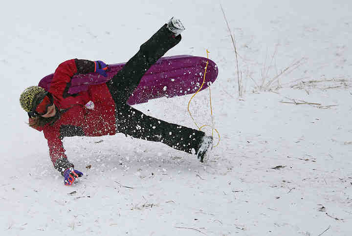 Zella Wingfield takes a tumble while sledding during a snowy day off school at Griggs Reservoir. There was no school due to the Martin Luther King Jr. holiday.   (Adam Cairns / The Columbus Dispatch)